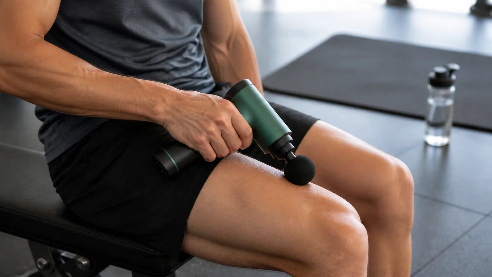 athlete using a hot and cold massage gun on the thigh after exercise